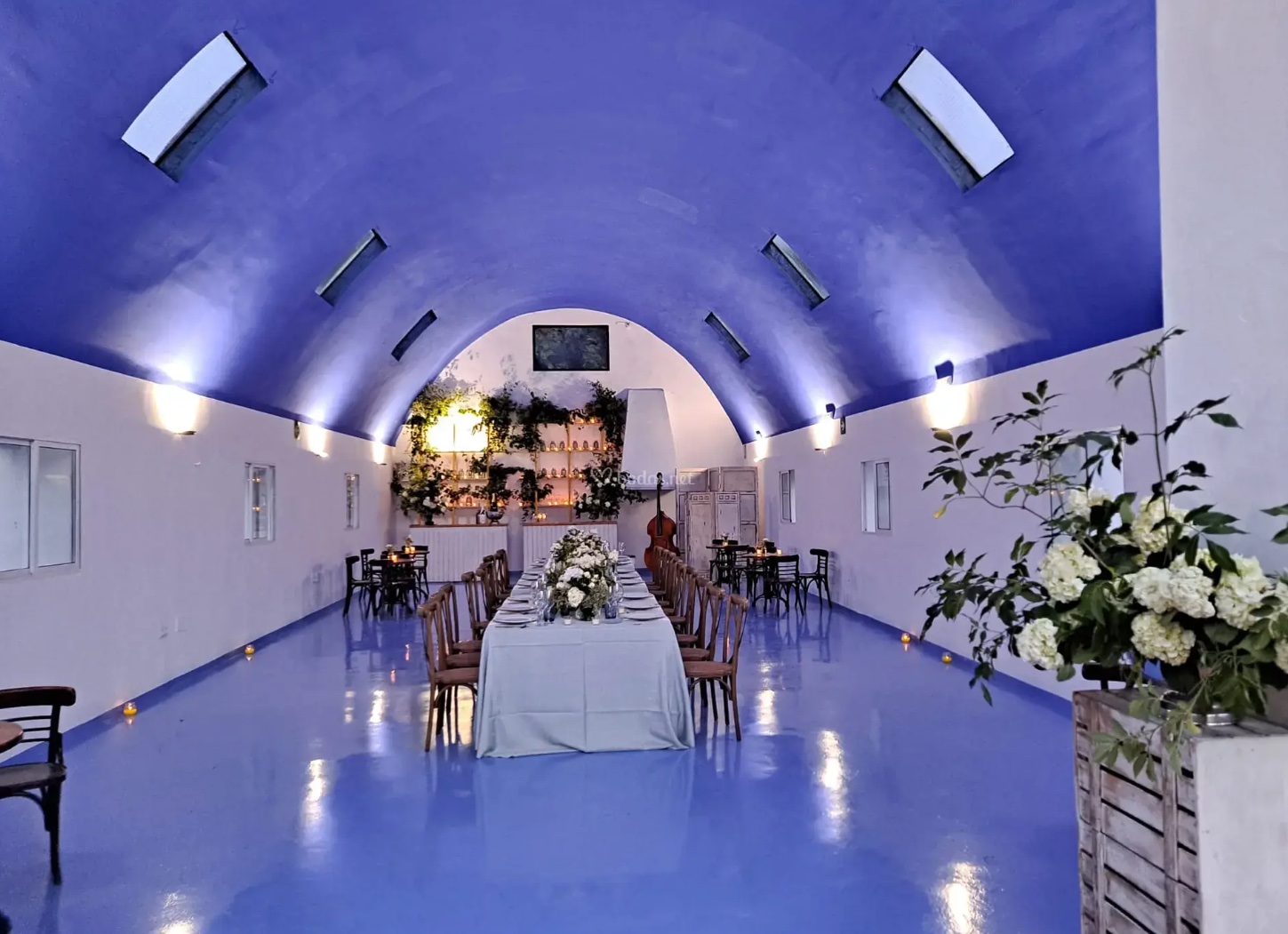 Salón abovedado con mesa presidencial vestida de blanco
